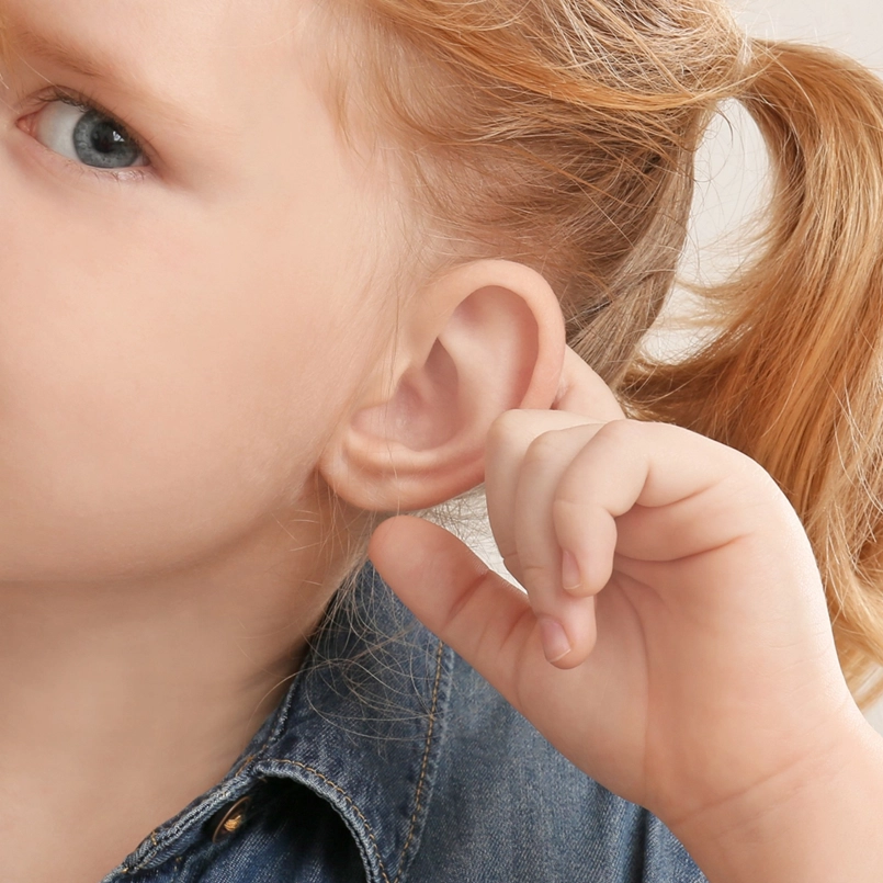 Image of a child holding ear for otoplasty, lobe repair, procedure. Photo for Marquis Plastic Surgery, Coral Gables, Miami, West Palm Beach, FL.
